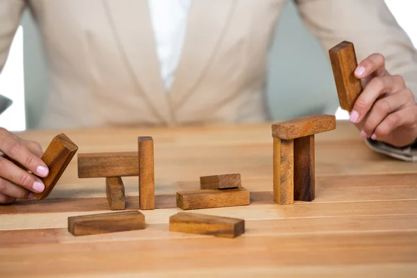 Businesswoman placing wooden block on a tower — Stock Photo, Image