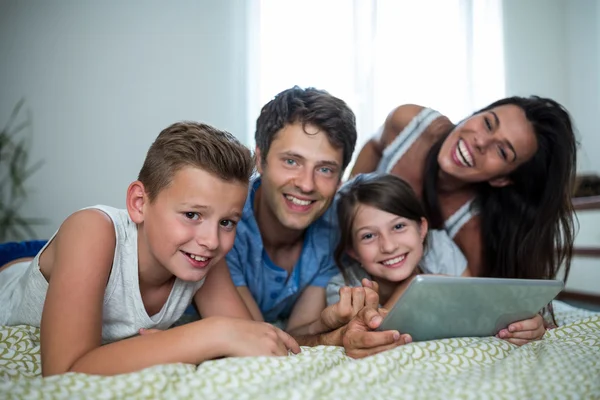 Family using tablet in bedroom at home — Stock Photo, Image