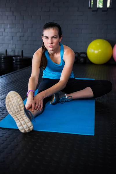 Young athlete stretching in gym — Stock Photo, Image