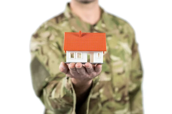 Soldado sosteniendo una casa modelo — Foto de Stock
