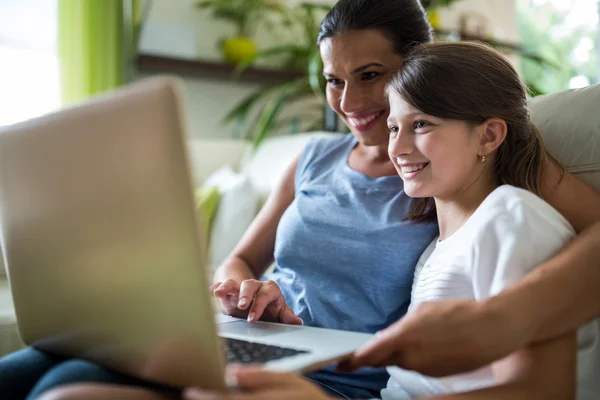 Madre e figlia utilizzando laptop e tablet digitale in soggiorno — Foto Stock