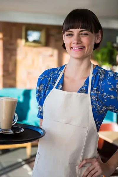 Улыбающаяся официантка держит стакан кофе — стоковое фото