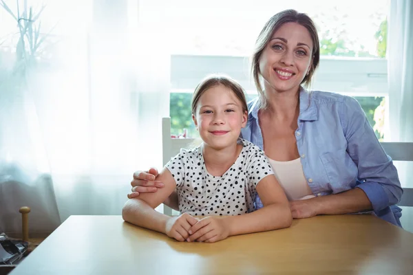 Mother and daughter leaning on table — Stock Photo, Image