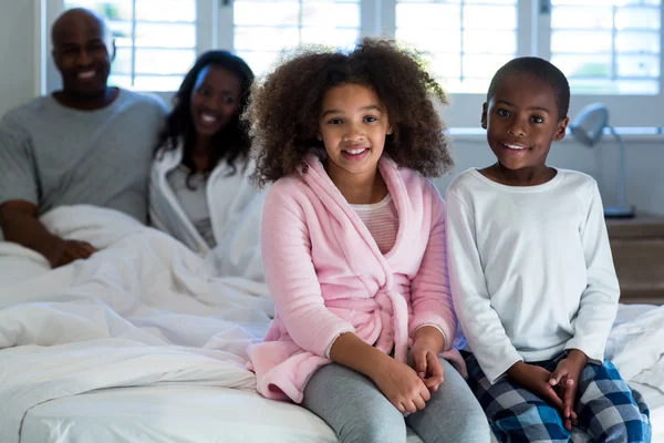 Kinderen zitten op bed — Stockfoto