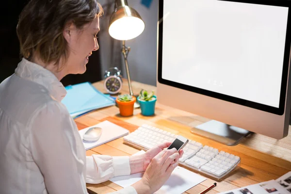 Femme d'affaires utilisant le téléphone portable à son bureau — Photo