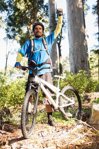 Podekscytowany mountain biker w lesie — Zdjęcie stockowe