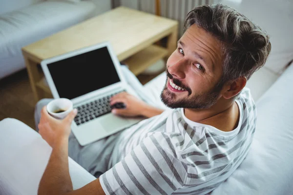 Pai usando laptop enquanto toma café — Fotografia de Stock