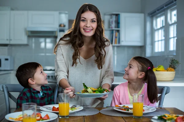 Moeder serveert ontbijt aan hun kinderen — Stockfoto