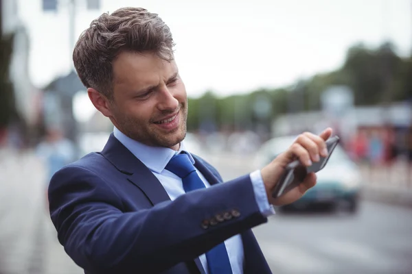 Bonito empresário segurando telefone celular — Fotografia de Stock