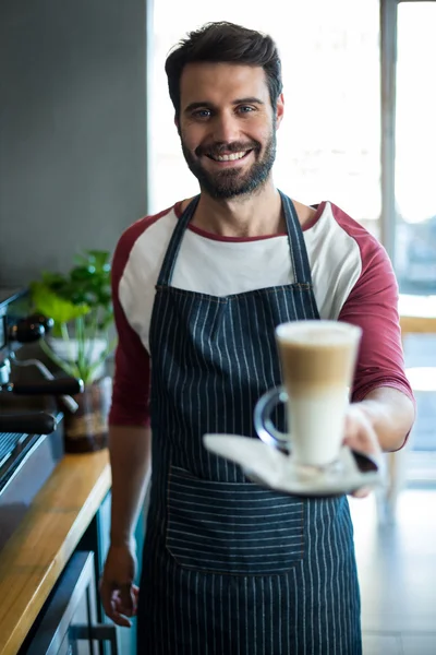 Официант держит кофе у стойки в кафе — стоковое фото