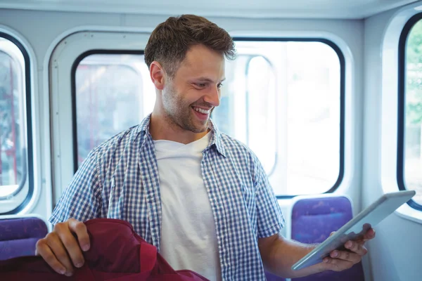 Pohledný muž pomocí digitálních tabletu ve vlaku — Stock fotografie