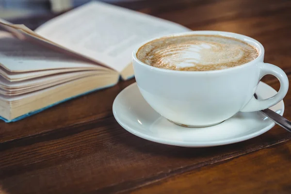 Cappuccino e livro na mesa — Fotografia de Stock