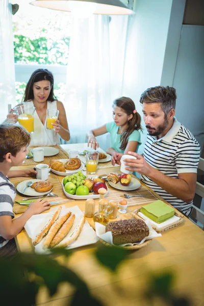 Family talking to each other while having breakfast — Stockfoto