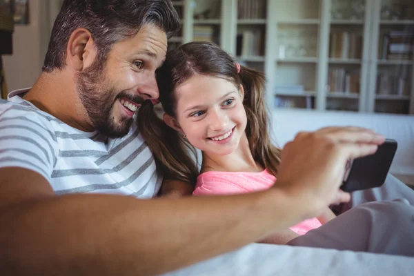 Far och dotter tittar på telefon — Stockfoto