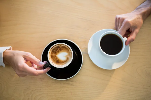 Handen van paar bedrijf kopje koffie — Stockfoto