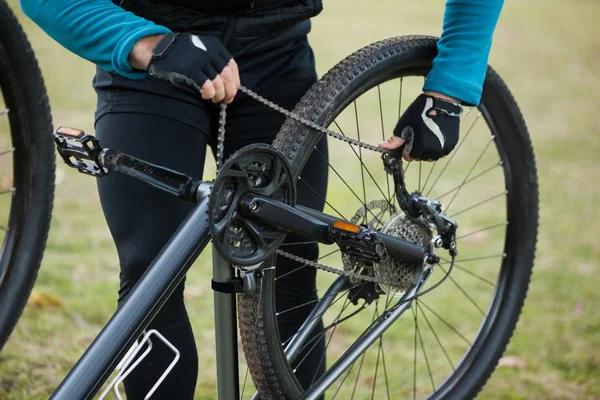 Mannelijke mountainbiker vaststelling van zijn fiets ketting — Stockfoto
