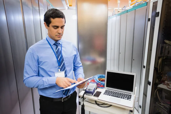 Técnico olhando para a lista de verificação — Fotografia de Stock