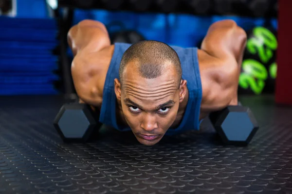 Homem sério fazendo flexões com halteres — Fotografia de Stock