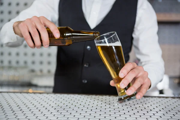 Barista versare birra su vetro — Foto Stock