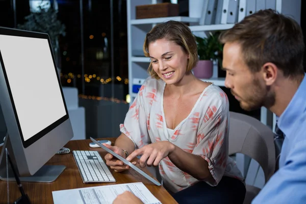 Businesswoman discussing with colleague over tablet — Stock Photo, Image