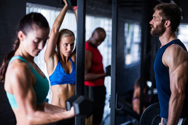 Friends lifting dumbbells while working out — Stock Photo, Image