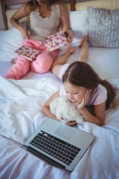 Córka za pomocą laptopa i matki otwarcie obecny — Zdjęcie stockowe