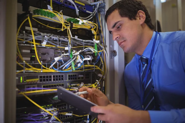 Technician maintaining record of rack mounted server — Stockfoto