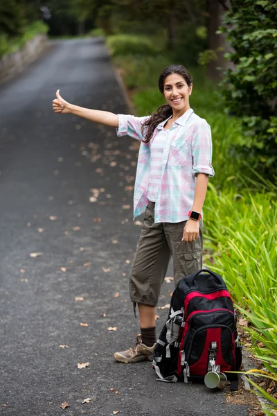 Woman hitchhiking on countryside road — Stock Photo, Image