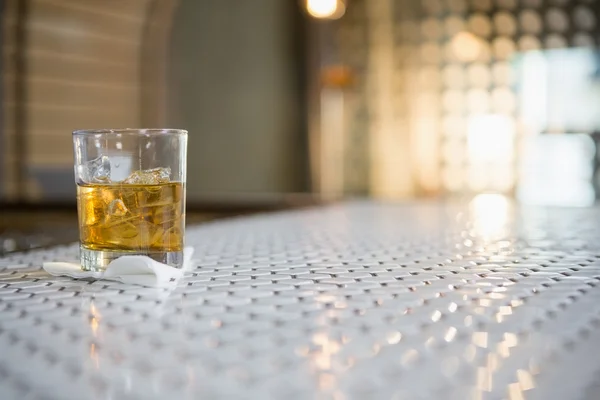 Vaso de whisky con cubo de hielo en barra — Foto de Stock