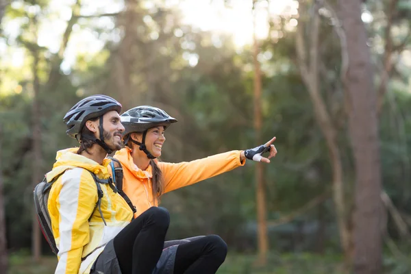 Biker casal sentado e apontando na distância — Fotografia de Stock