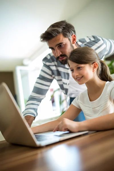 父亲和女儿在客厅里使用笔记本电脑 — 图库照片