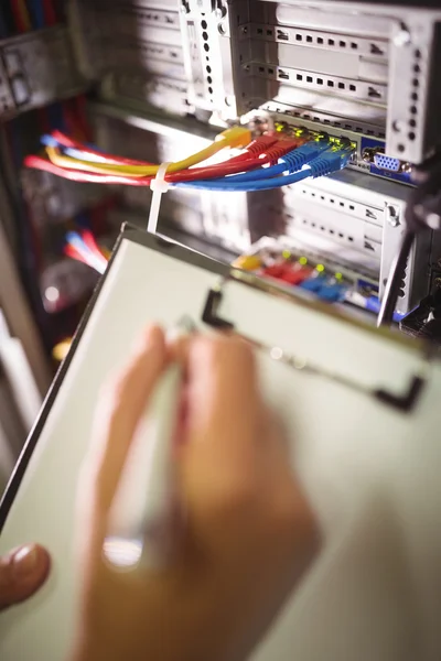 Técnico manteniendo registro de servidor montado en rack — Foto de Stock