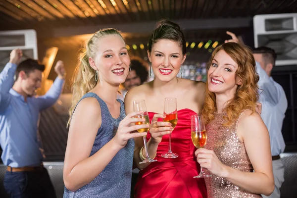 Female friends holding a glass of champagne — Stock Photo, Image