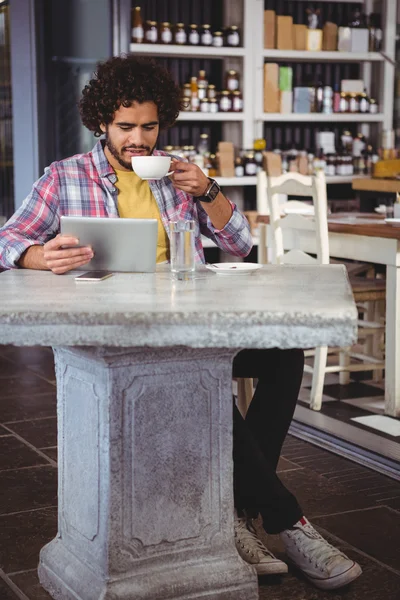 Muž s kávu při pohledu na tabletu — Stock fotografie