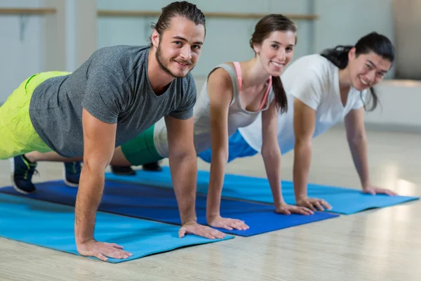 Fitnessteam macht Liegestütze — Stockfoto