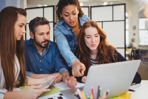 Zakenvrouw wijzend op laptop met collega 's — Stockfoto