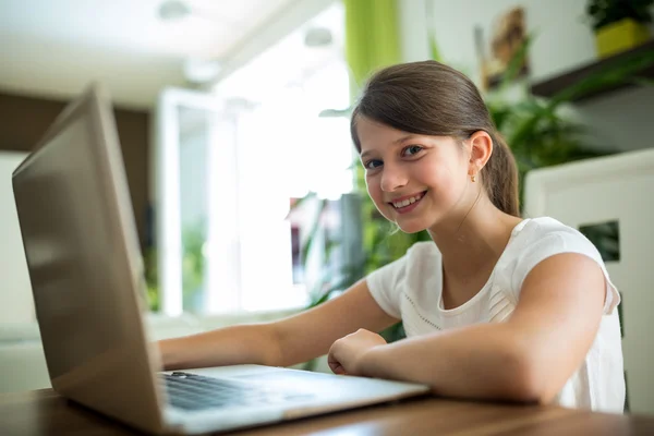 Portrait of smiling girl with laptop in the living room — Stock Photo, Image