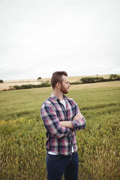 Promyšlené farmář s rukama zkříženýma v poli — Stock fotografie