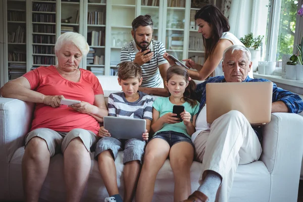 Família de várias gerações usando laptop, telefone e tablet — Fotografia de Stock