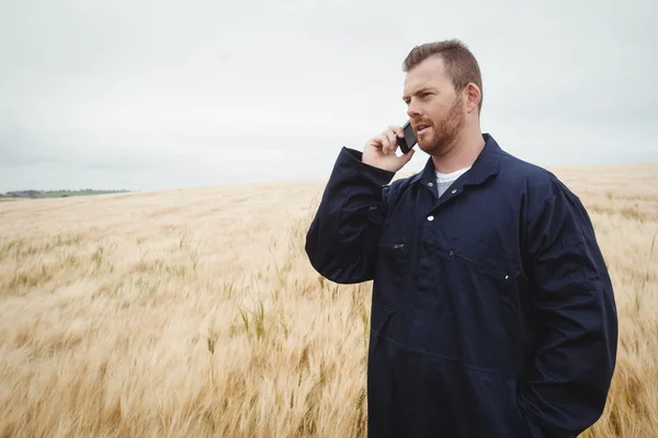 Boer praten over telefoon in het veld — Stockfoto