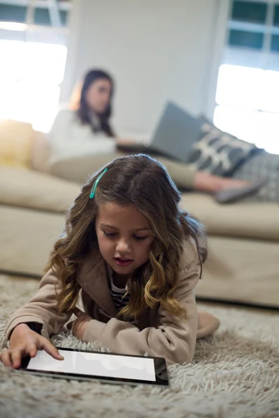 Chica usando tableta mientras está acostado en el suelo — Foto de Stock