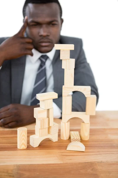 Thoughtful businessman building tower of blocks — Stock Photo, Image