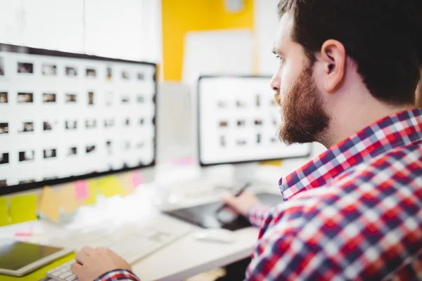 Editor concentrating on photographs in computer — Stock Photo, Image