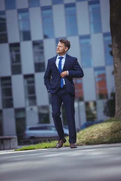 Businessman walking on road — Stock Photo, Image