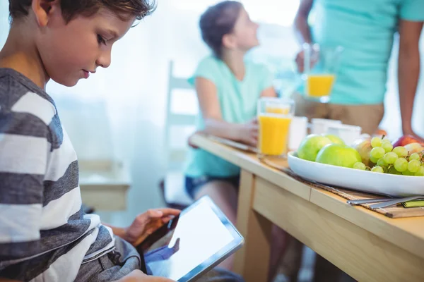 Boy using digital tablet with breakfast on table — Stock fotografie