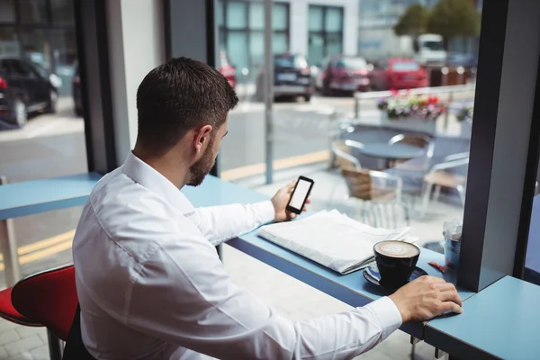 Homem usando telefone enquanto toma café — Fotografia de Stock