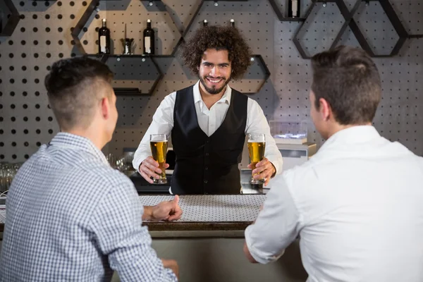 Cantinero sirviendo cerveza a los clientes — Foto de Stock