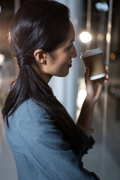 Businesswoman holding disposable coffee cup — Stock Photo, Image