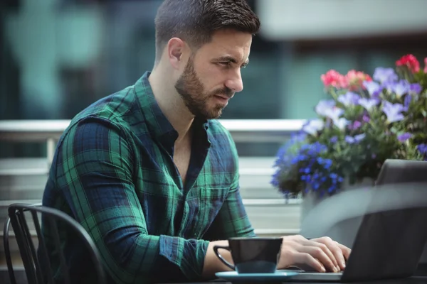 Businessman using laptop while having coffee — Stock Photo, Image