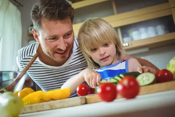 Pai e filha cortando legumes — Fotografia de Stock